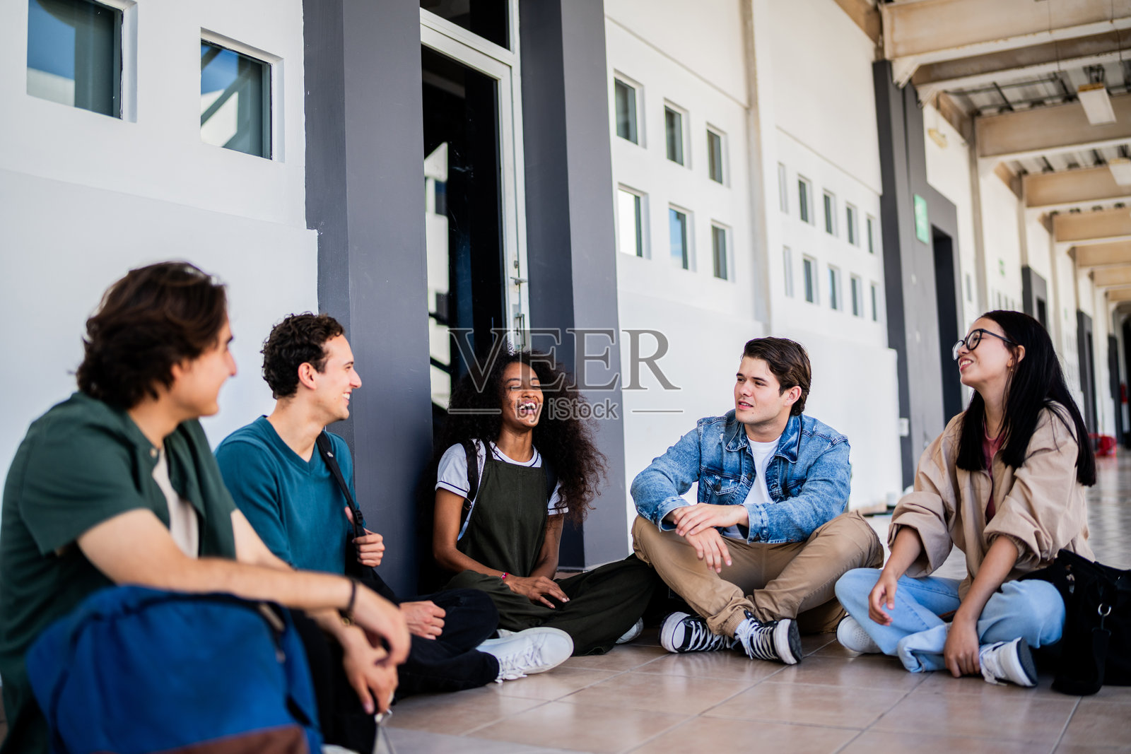 年轻学生朋友在大学里交谈照片摄影图片
