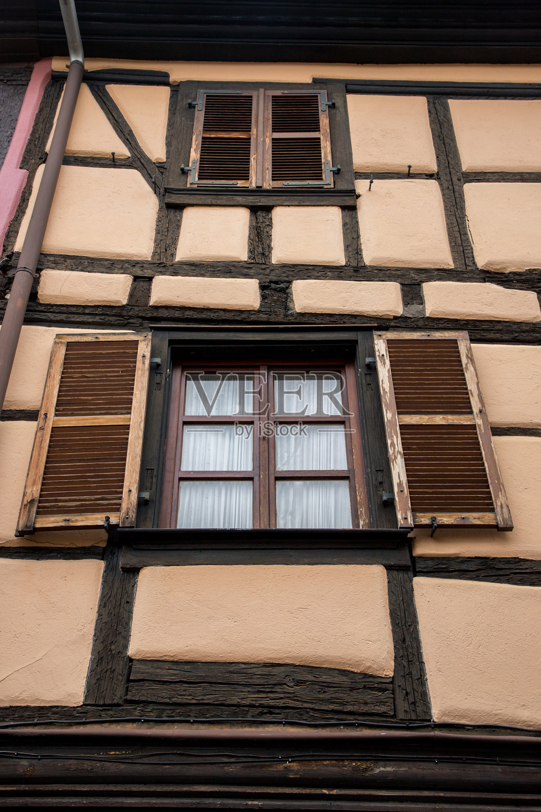 法国阿尔萨斯的老式半木结构房屋,黄色竖版。照片摄影图片