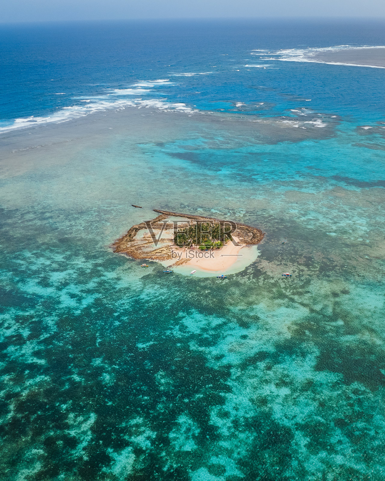 希阿高的古亚姆岛鸟瞰图 - 一座被清澈海水、白色沙滩和郁郁葱葱的棕榈树环绕的小而美丽的岛屿,提供完美的乐园体验!照片摄影图片