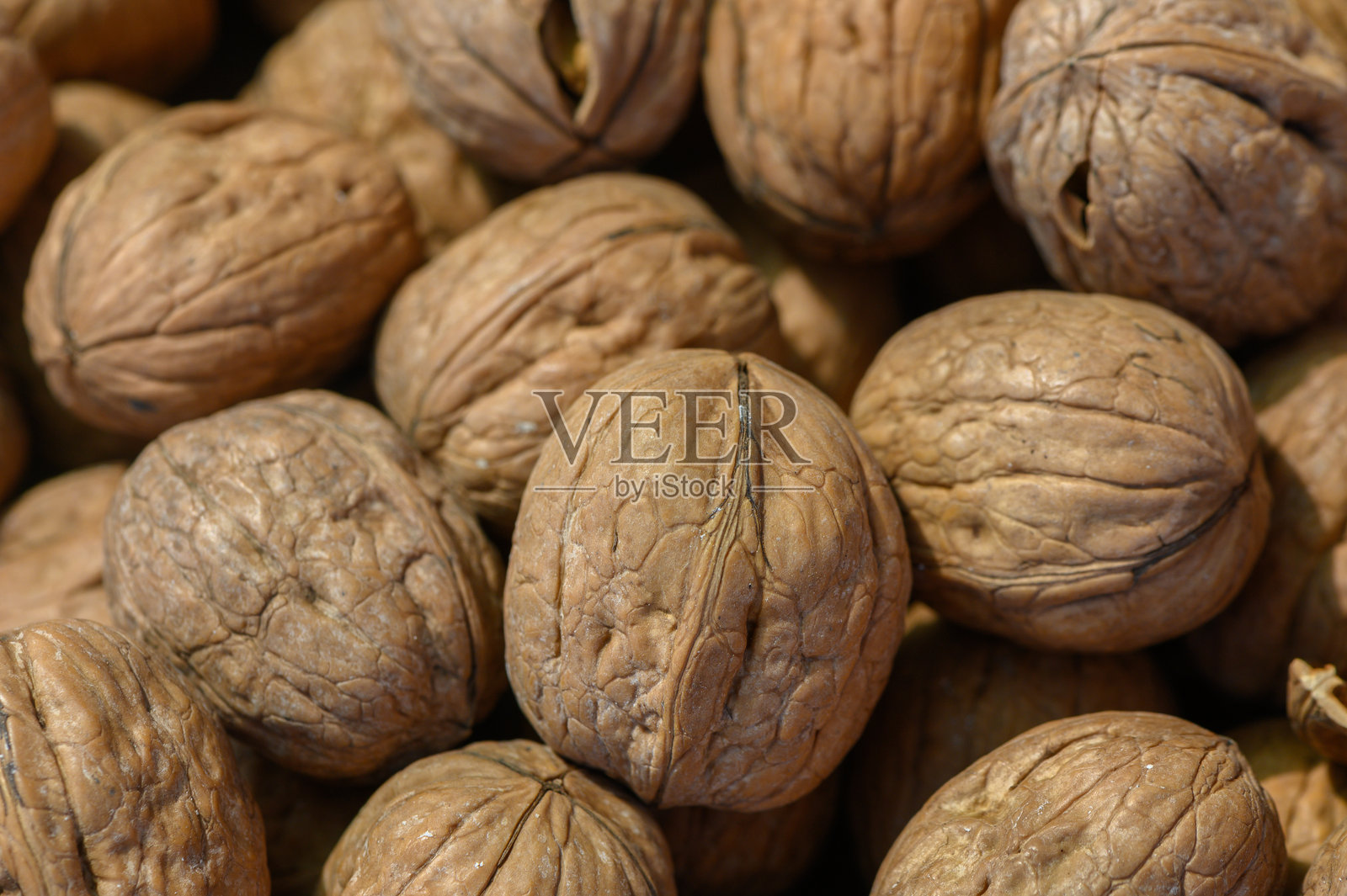 坚果散落在温暖宜人的厨房木质表面上,营造出一种庆祝自然丰收的温馨氛围。照片摄影图片