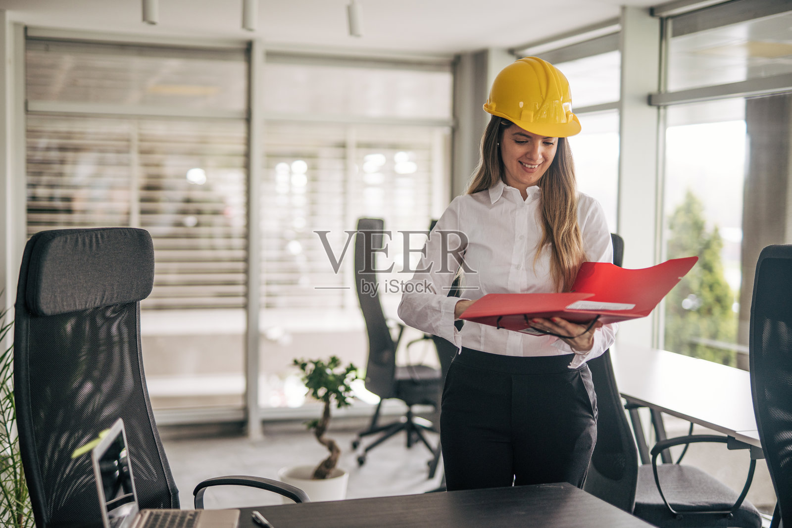 女性建筑师在现代办公室审阅文件照片摄影图片