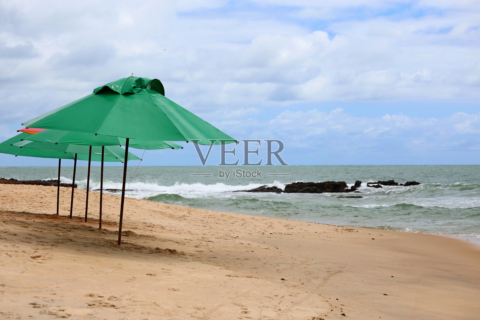 沙滩上的绿色遮阳伞在等待游客照片摄影图片