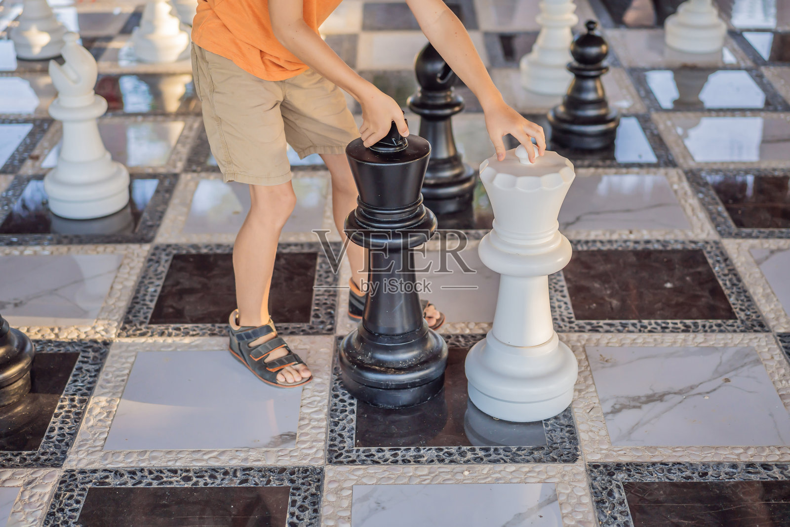 父亲和儿子在户外下棋,共度时光。孩子在下棋。照片摄影图片