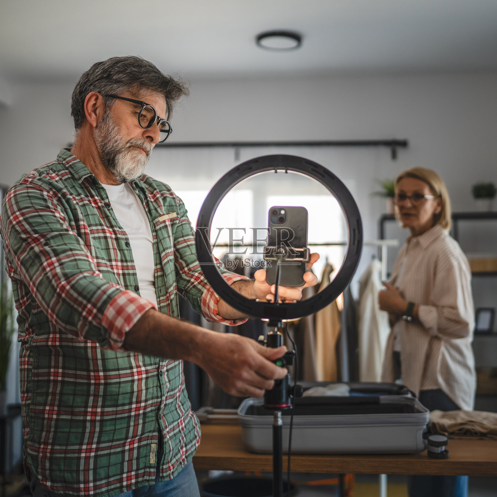成熟的老年男性站着准备摄像机设备进行直播照片摄影图片