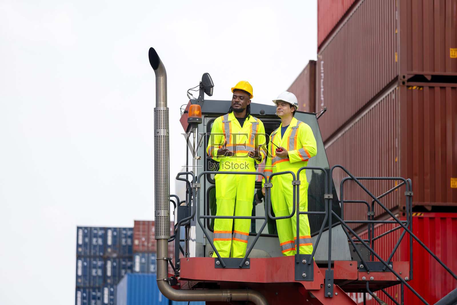 工业场地的码头工人团队穿着安全装备,集装箱码头工人正在讨论照片摄影图片