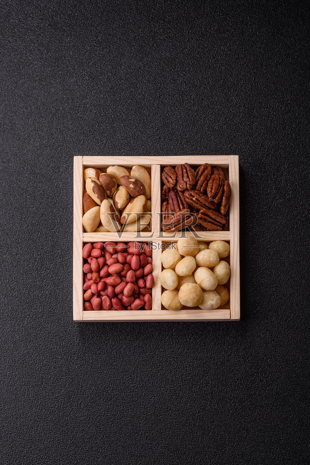 装有夏威夷果、巴西坚果、胡桃和花生的木箱照片摄影图片