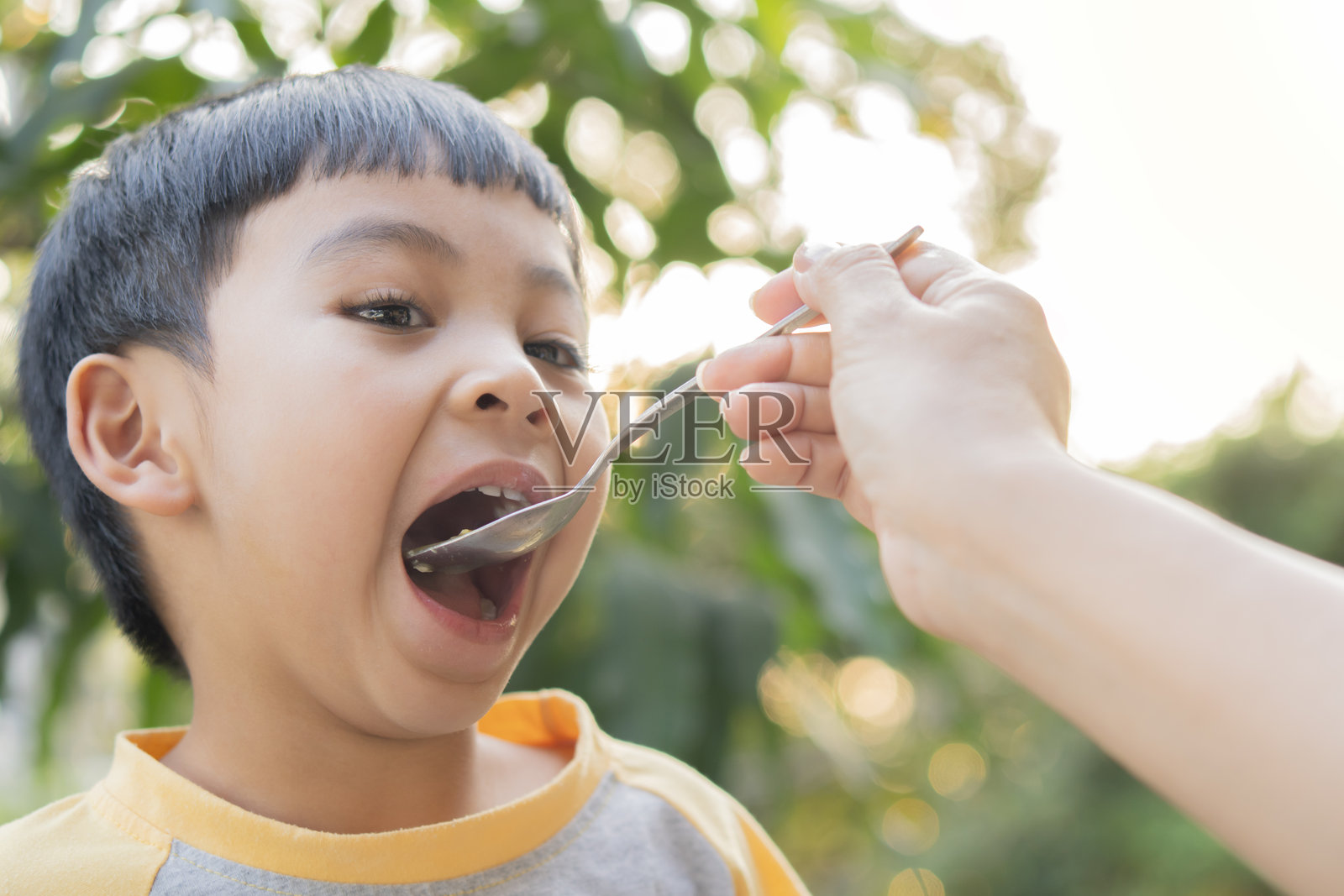 快乐的学龄前儿童在家里的花园里享用新鲜烹饪的健康餐,包括鸡蛋和蔬菜。照片摄影图片