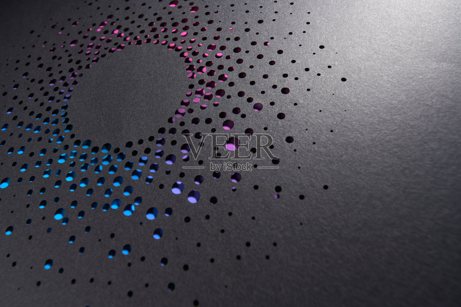 抽象的放射状纸雕设计,圆形孔洞展示出鲜艳的蓝色和紫色渐变背景照片摄影图片