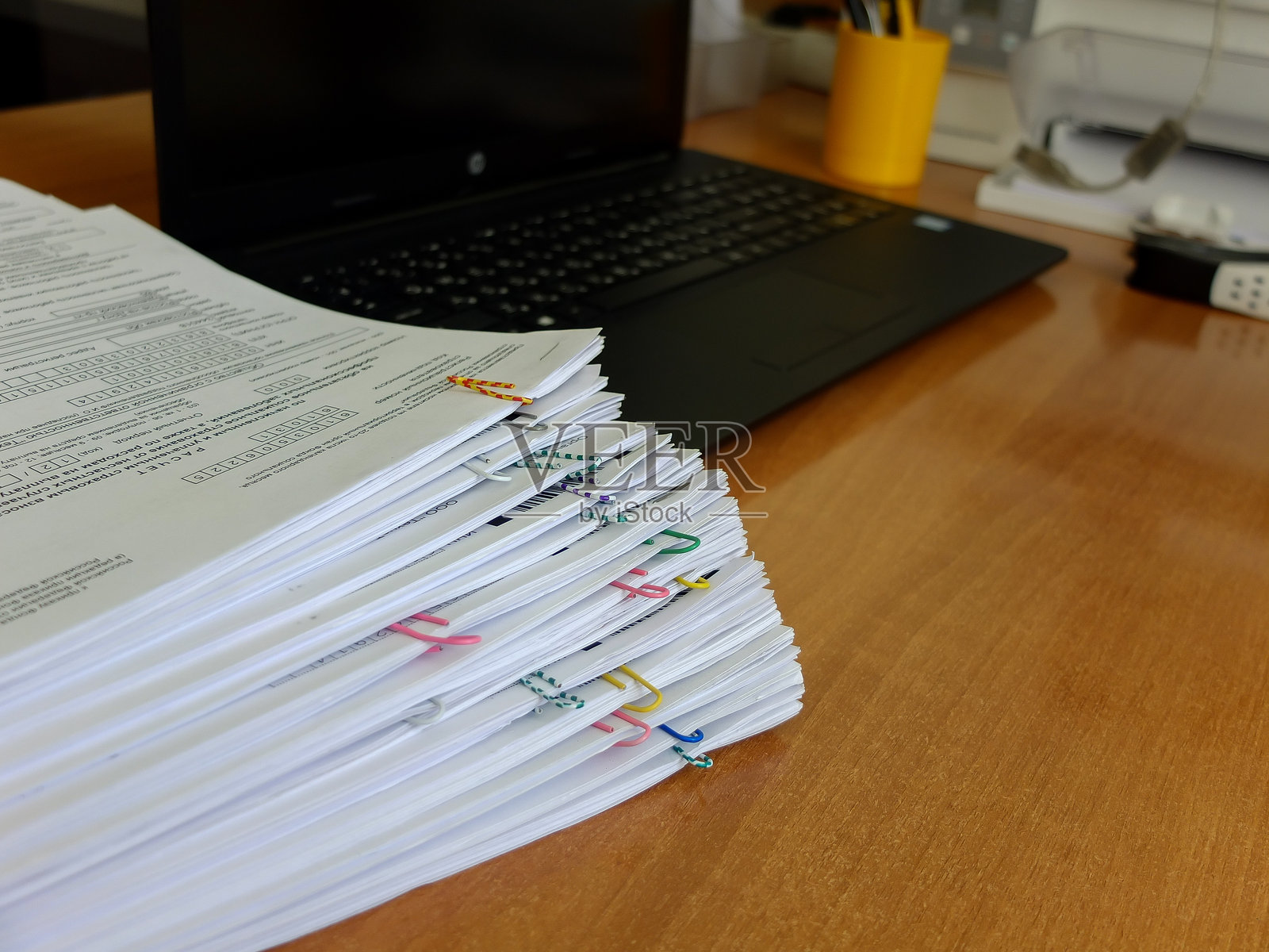 一堆装订好的文件放在笔记本电脑背景上照片摄影图片