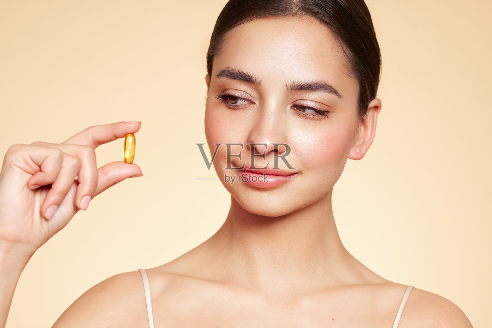 美丽女孩与含有鱼肝油Omega-3的胶囊照片摄影图片