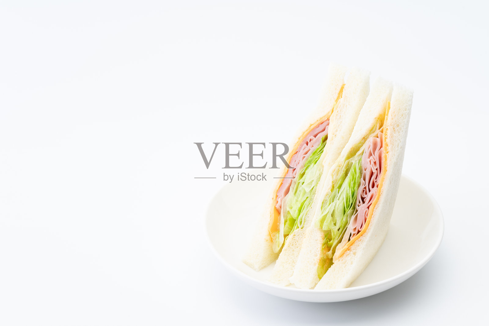 看起来美味的火腿、奶酪和生菜三明治放在盘子上照片摄影图片