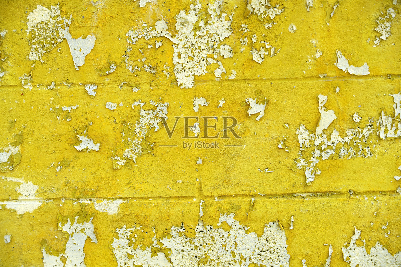 明亮的黄色墙壁,剥落的油漆和受损的纹理照片摄影图片