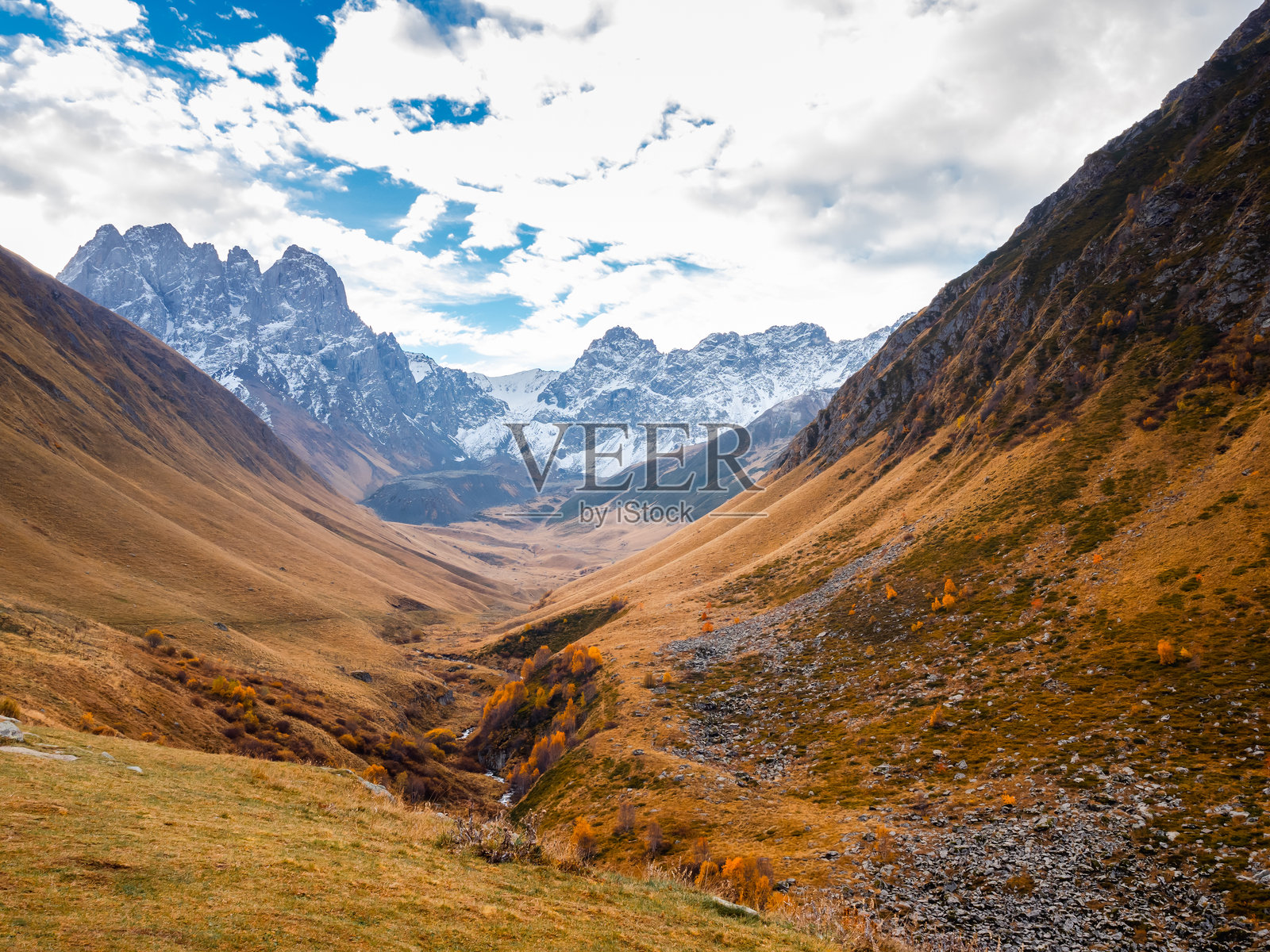 乔治亚州朱塔的山谷,秋天的黄色田野和复杂的丘陵,雪山峰背景,步行小径的景观。小山上的干草,优美的风景。照片摄影图片