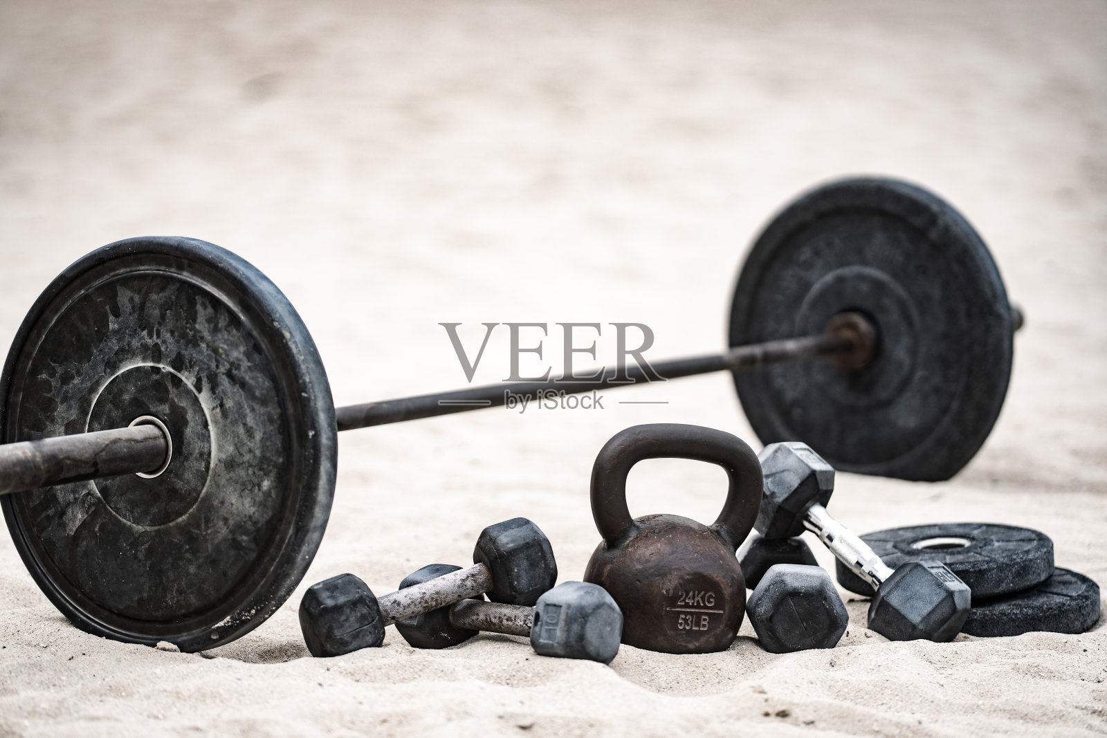 壶铃训练。沙滩上的哑铃。户外健身运动。举重锻炼。杠铃举重。运动激励锻炼。照片摄影图片