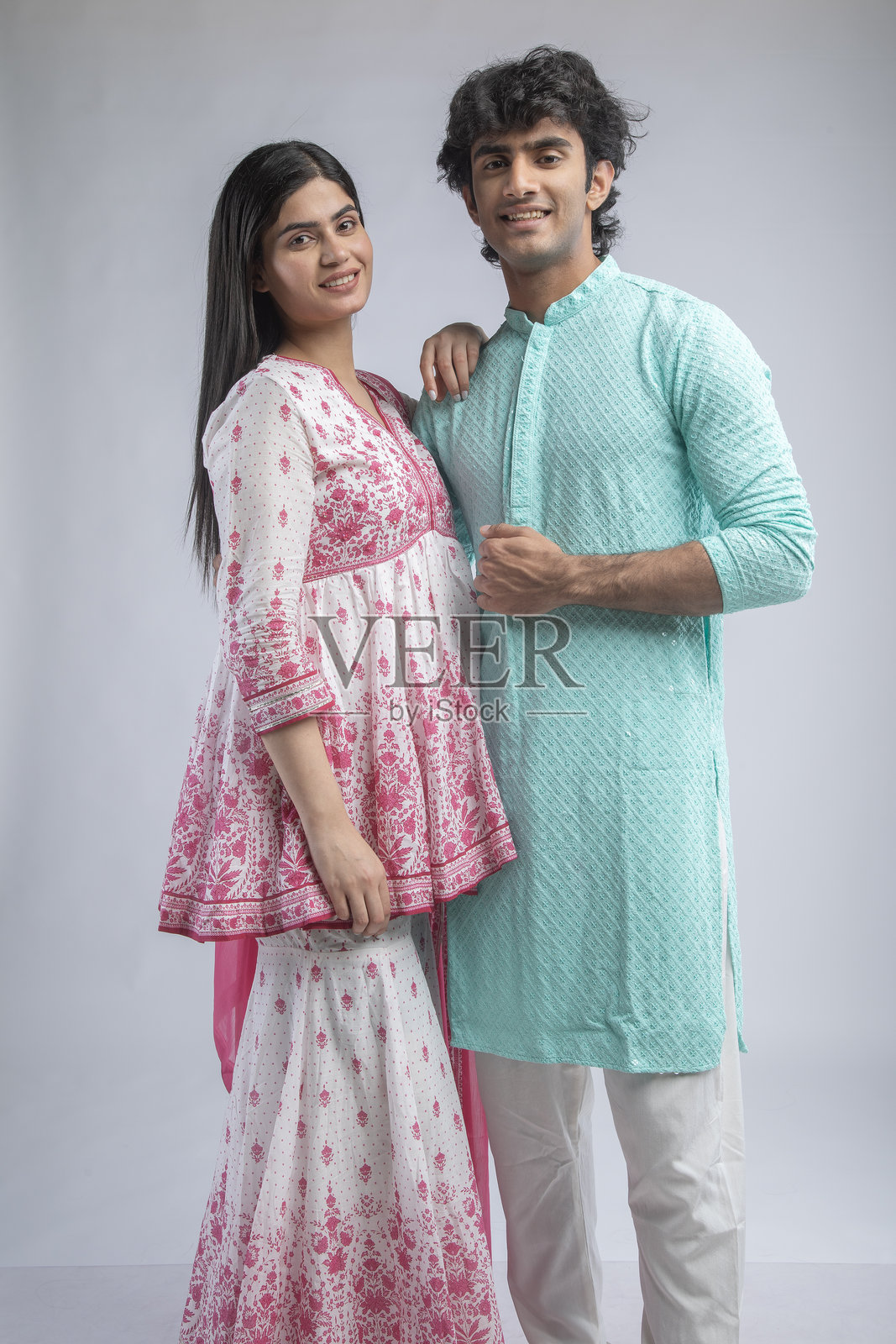 穿着传统服装的幸福情侣站在白色背景前照片摄影图片