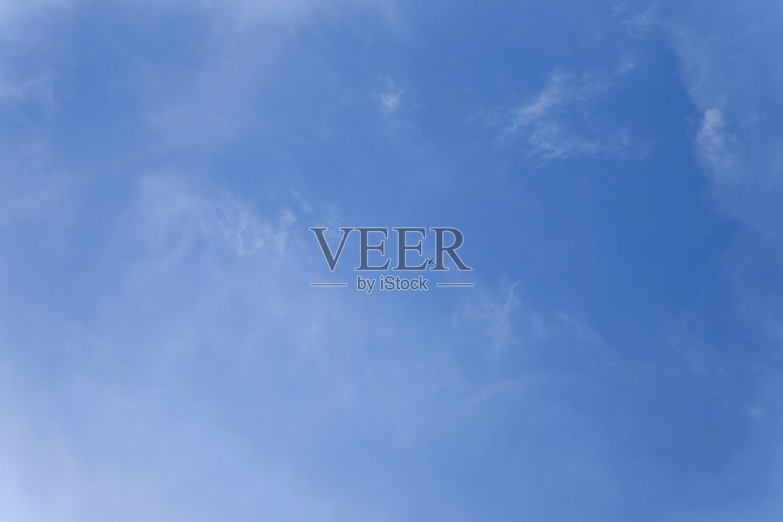 孤独的飞机在清澈的蓝天中飞翔,淡淡的云朵,极简旅行概念照片摄影图片