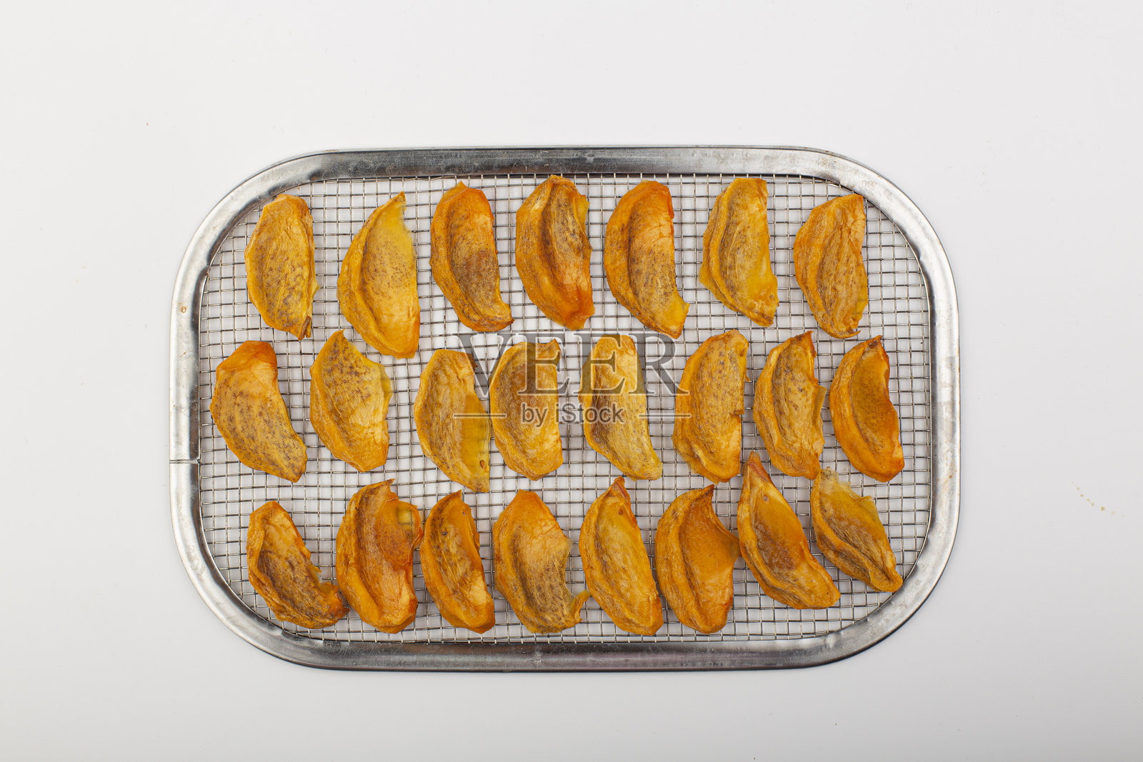 白色背景上的干柿子片。照片摄影图片