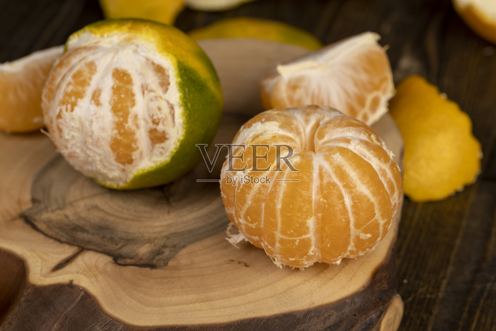 剥皮的橙子和成熟的橘子放在桌子上照片摄影图片