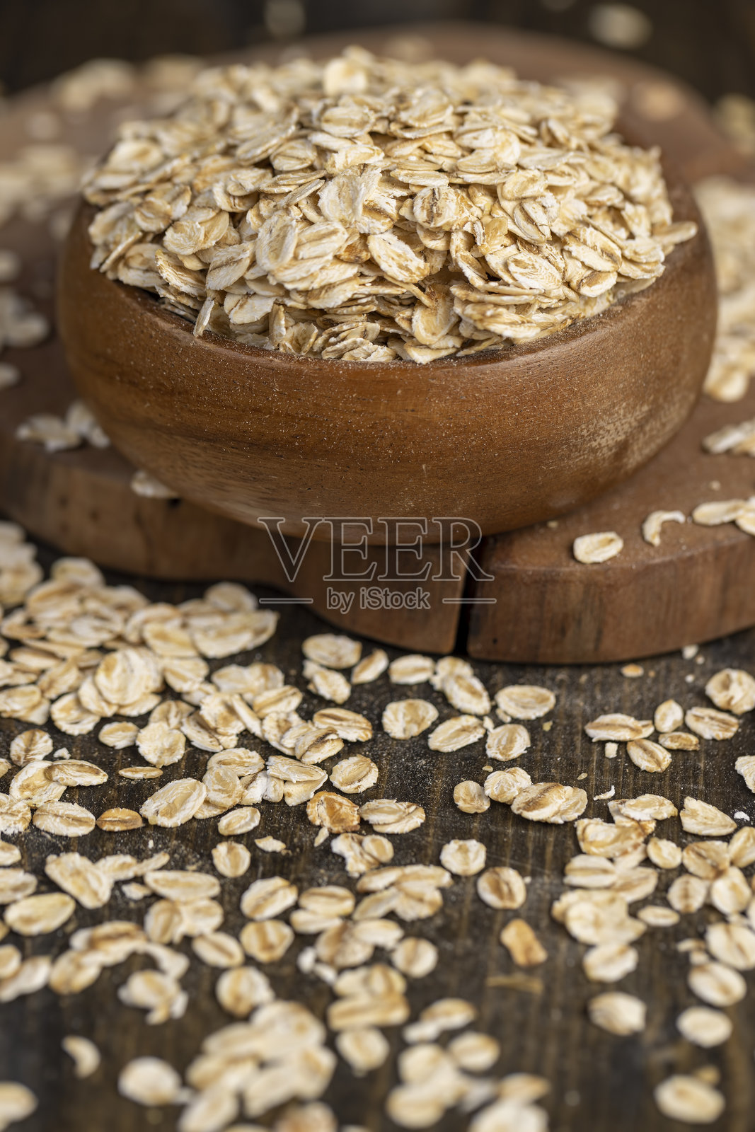 圆形木碗里装着燕麦片,用于制作粥。照片摄影图片