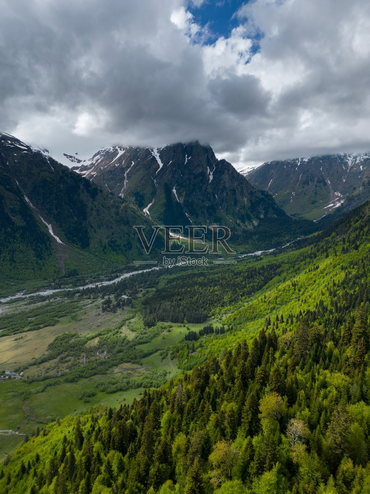 山谷草甸,云雾中的陡峭山峰,森林上空飞行,鸟瞰图照片摄影图片