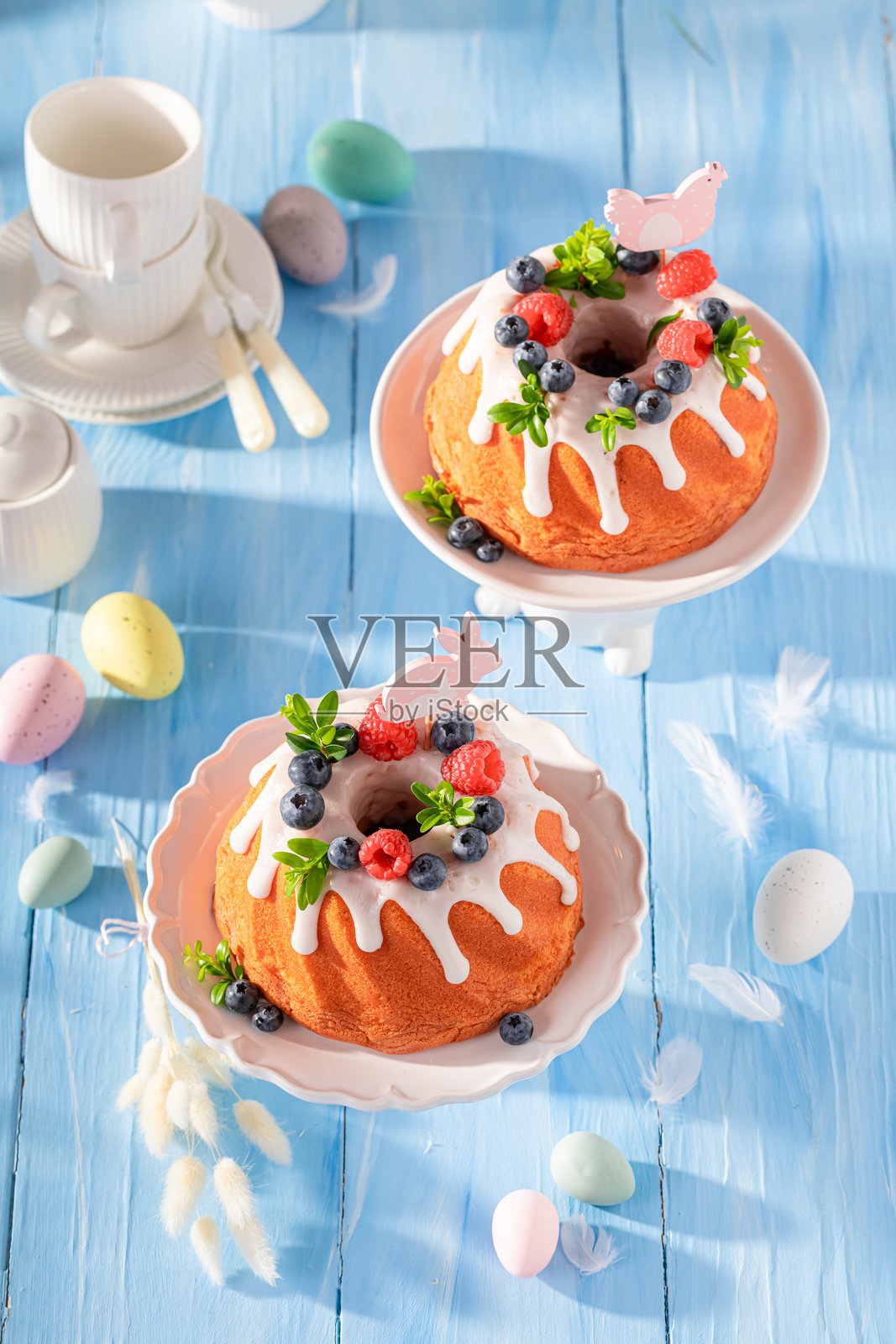 复活节花环蛋糕的特写,配有花朵和彩绘鸡蛋。照片摄影图片