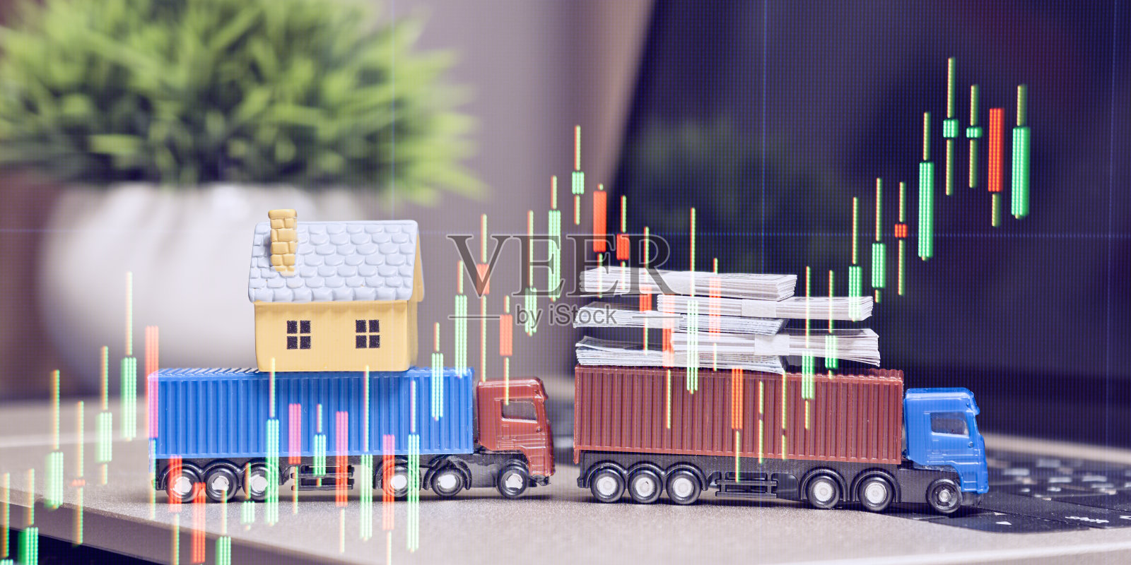 房子和金钱堆叠,上面覆盖着金融蜡烛图,象征着物流、房地产和投资市场。照片摄影图片
