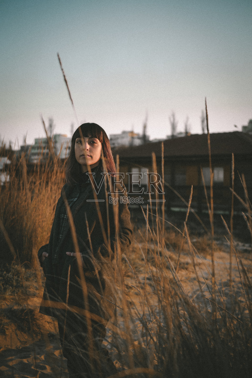 日落时分,女人站在田野上仰望天空照片摄影图片