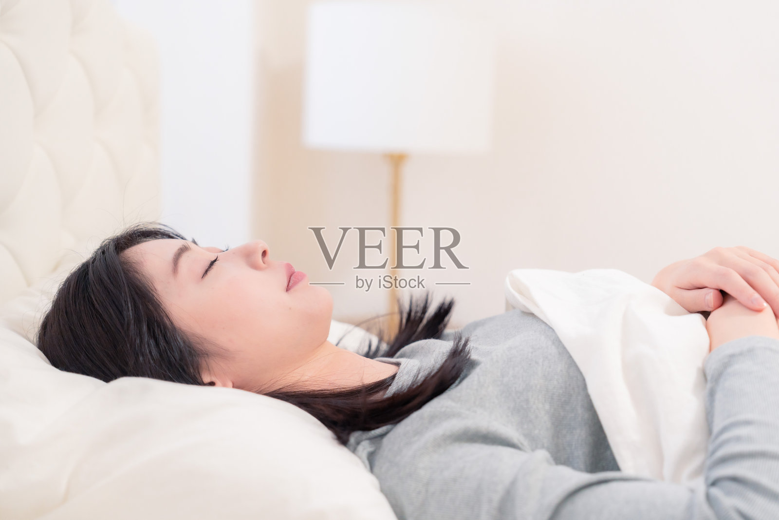 年轻女性在床上睡觉照片摄影图片