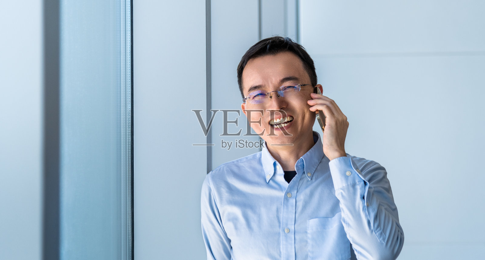 商人靠近窗户使用智能手机照片摄影图片