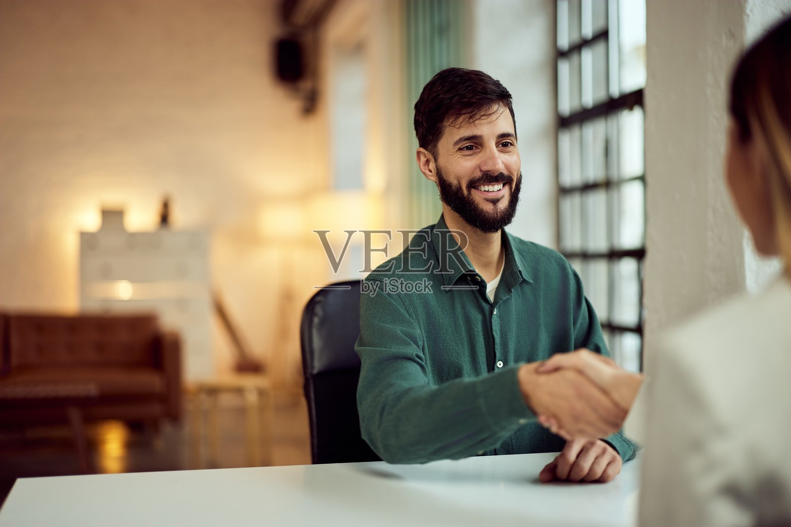 两位专业人士在现代办公室环境中友好握手照片摄影图片