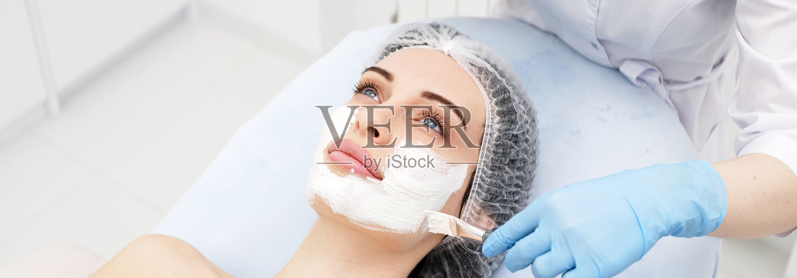 年轻女性在专业美容院进行面部护肤治疗的特写镜头。照片摄影图片