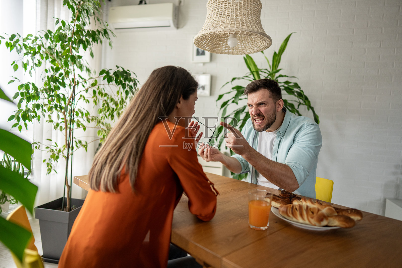 年轻情侣在家早餐时争吵照片摄影图片