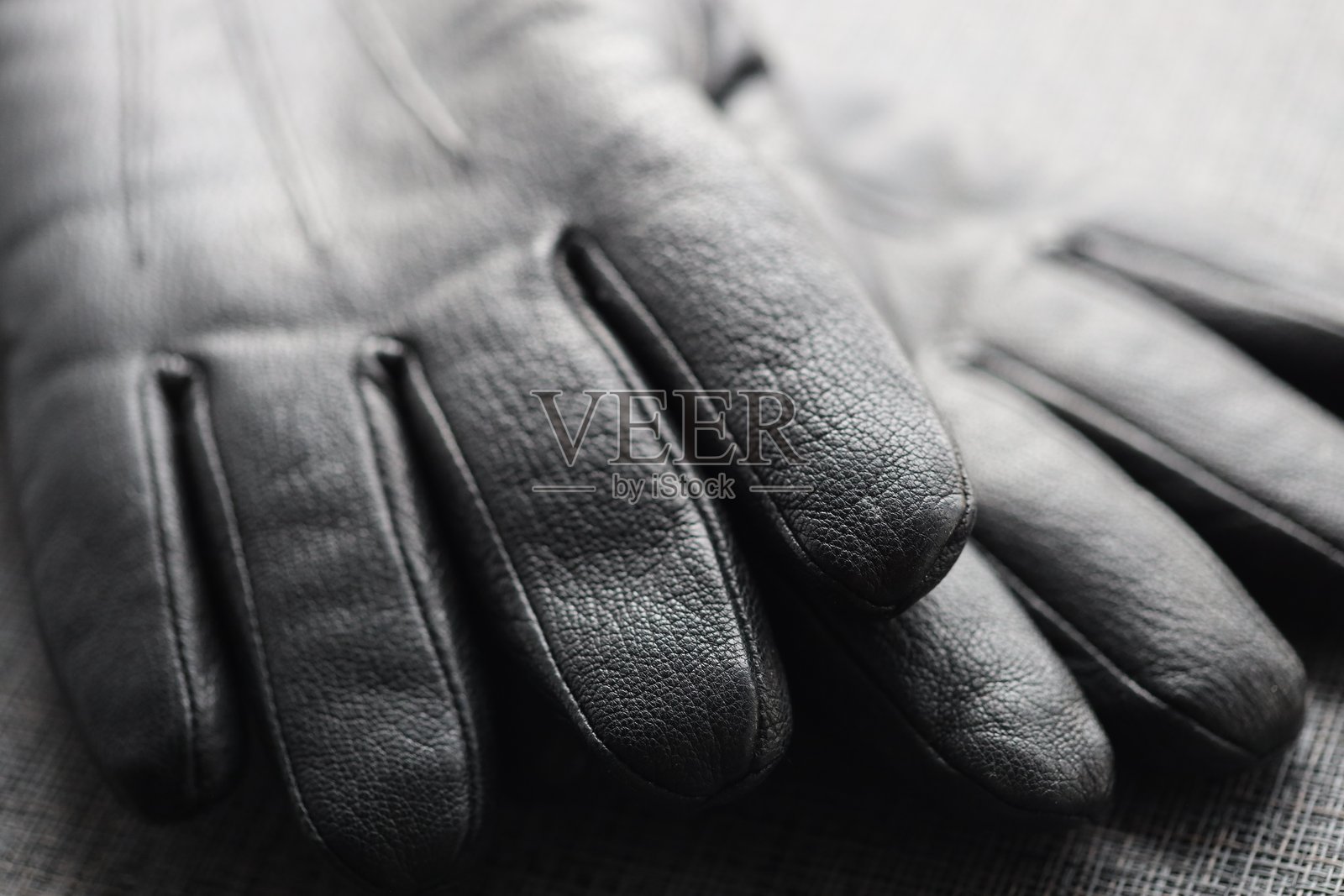 一双经典的黑白皮手套,非常适合正式场合或作为道具使用。照片摄影图片