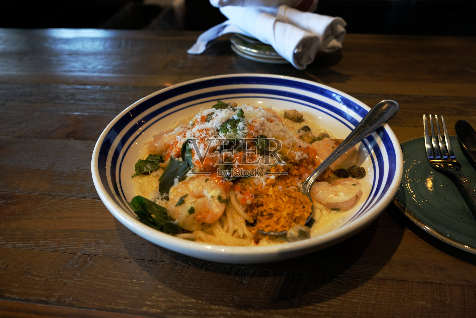 蓝条纹碗中的海鲜意大利面照片摄影图片