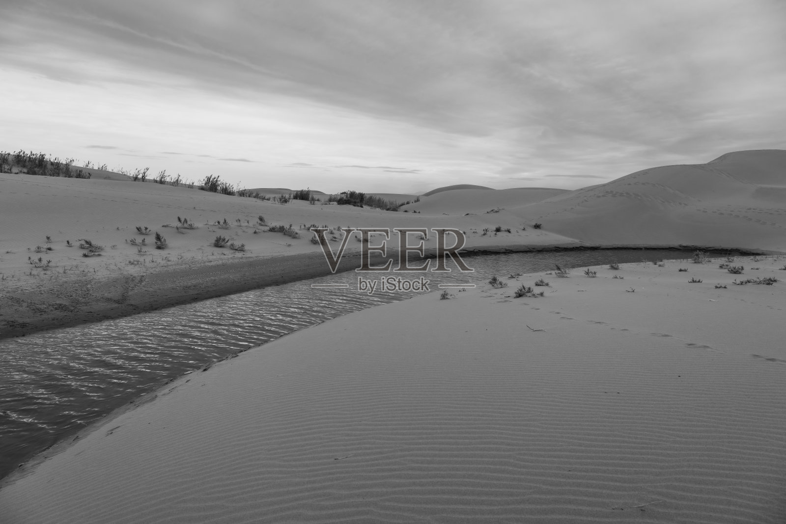 中国内蒙古戈壁沙漠上空的戏剧性天空与无尽的沙丘和河流照片摄影图片