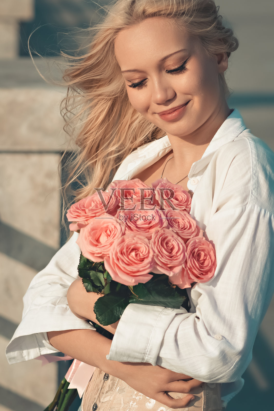 手捧玫瑰花束的少女照片摄影图片