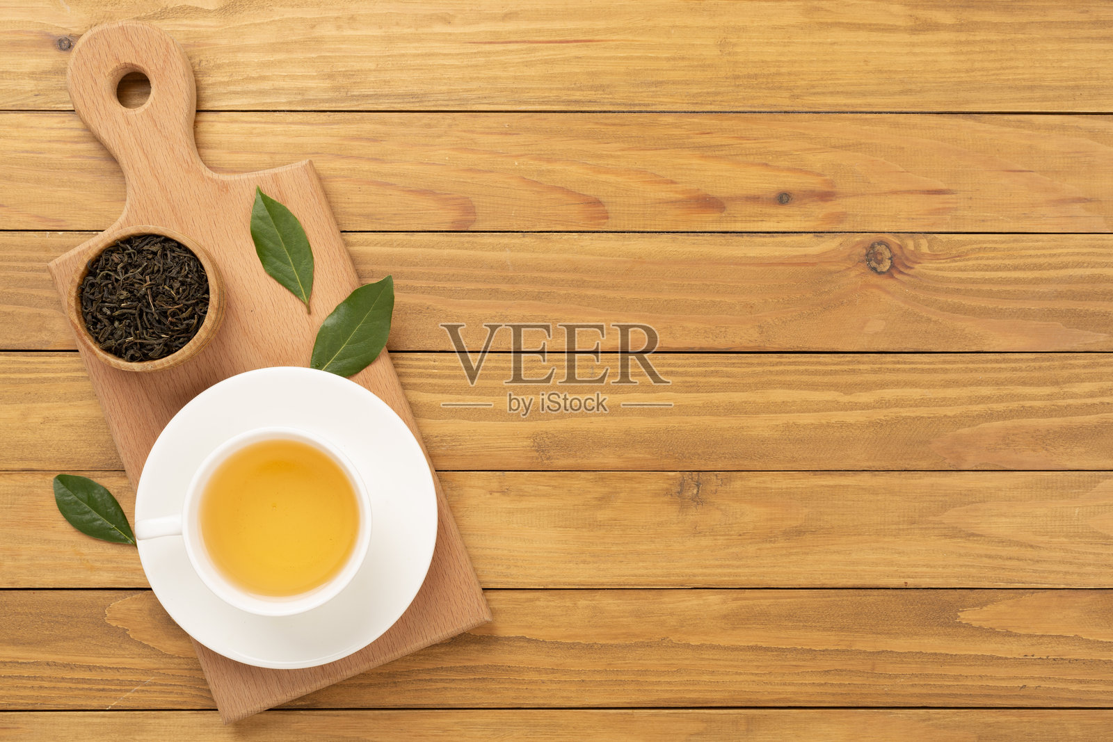 木质背景上的茶杯,干茶叶和新鲜茶叶,俯视图照片摄影图片