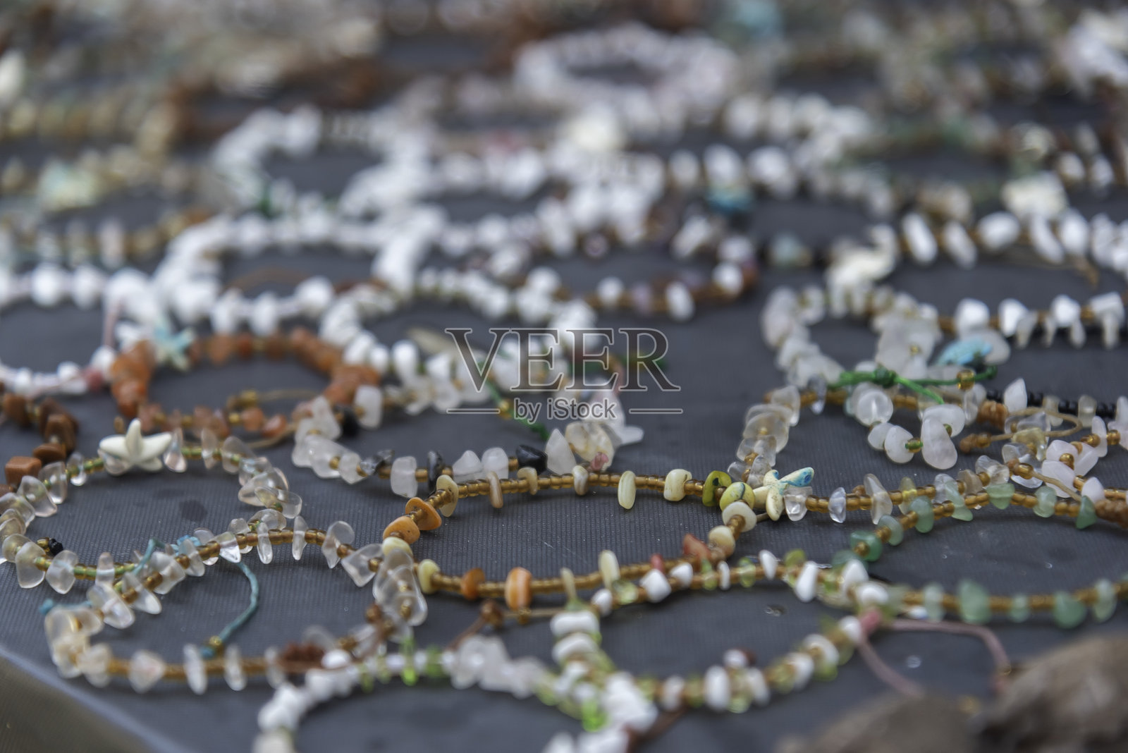 由莫肯社区村手工制作的石头手链和贝壳手链。莫肯人是生活在泰国普吉岛苏林群岛的海上吉普赛人,拥有永久居住地。照片摄影图片