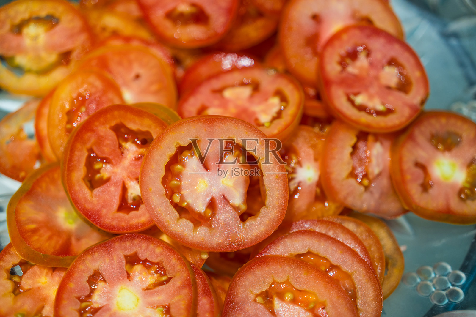 鲜艳的红番茄被切成厚厚的圆片,展示出多汁的果肉和种子。照片摄影图片