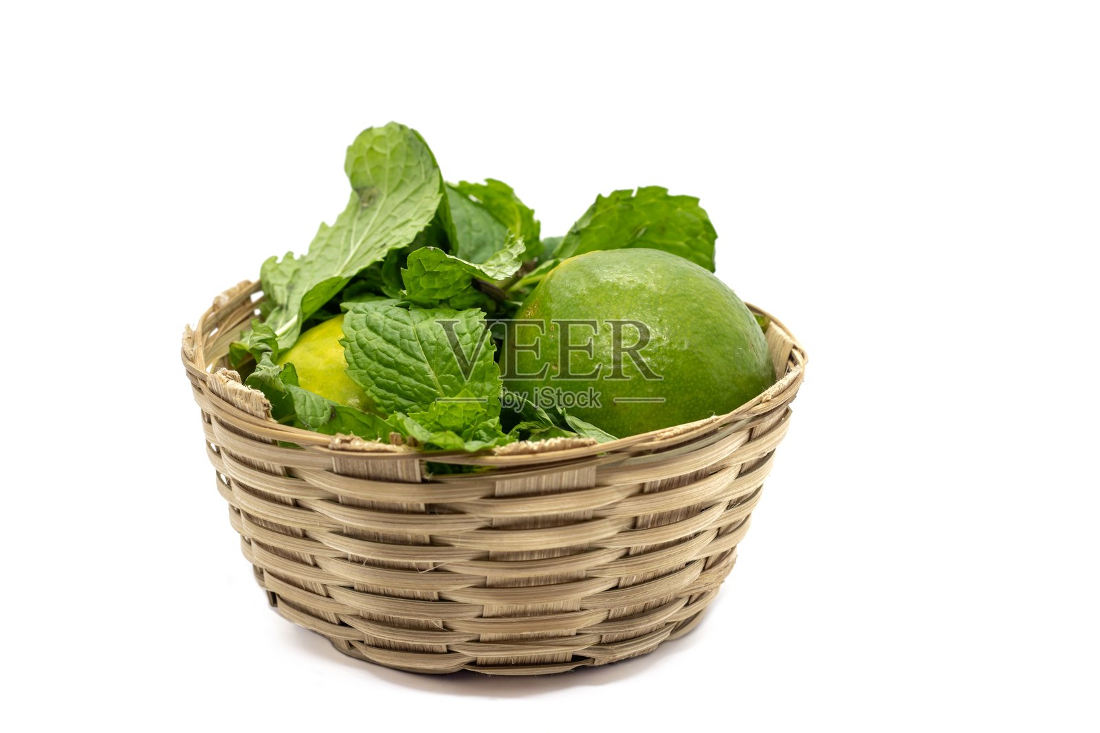 竹篮中的薄荷叶与青柠,背景为白色,留有空白空间。照片摄影图片