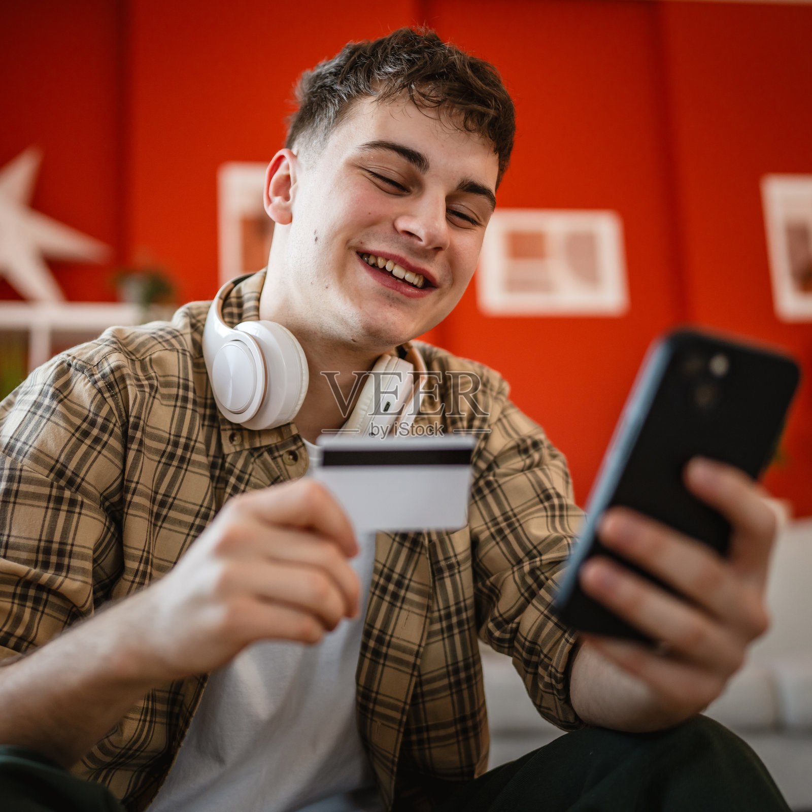 年轻男子在家中享受手机在线购物照片摄影图片