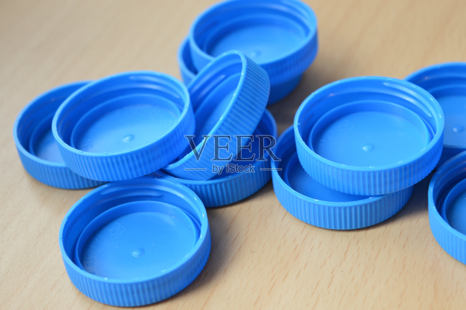 许多蓝色塑料瓶盖的特写视图,收集在一个白色塑料袋中,回收和废物分类意识,塑料再利用,升级改造,环保视觉,包装行业照片摄影图片