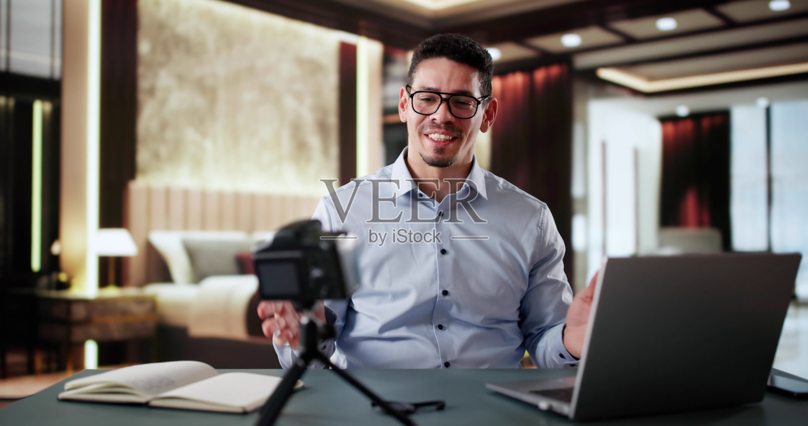 酒店房间里的旅行博主。快乐的男人在直播。照片摄影图片