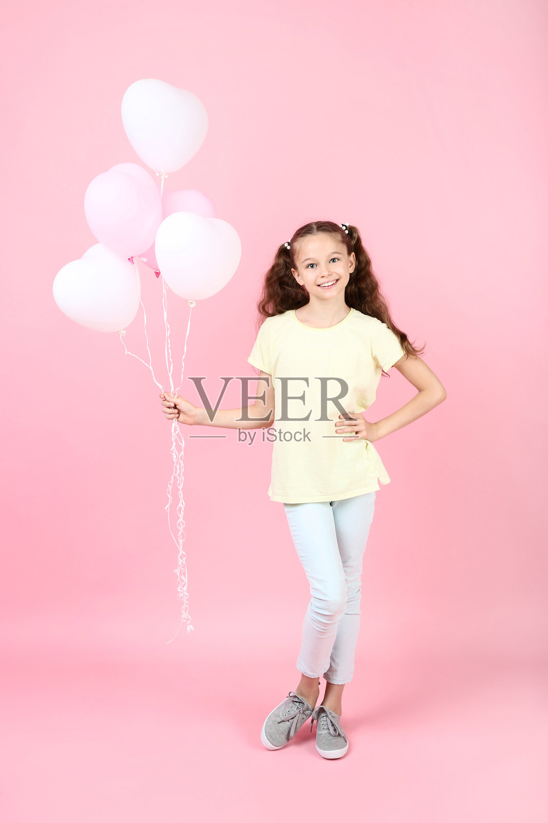 可爱的小女孩与气球在粉色背景上照片摄影图片