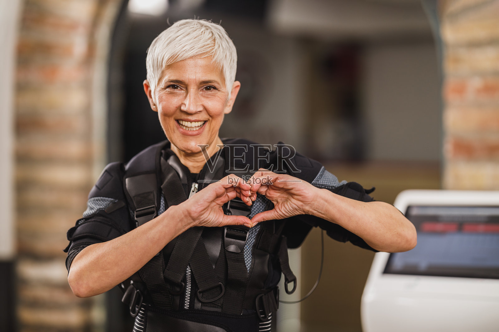 健身房内进行EMS训练的老年女性照片摄影图片