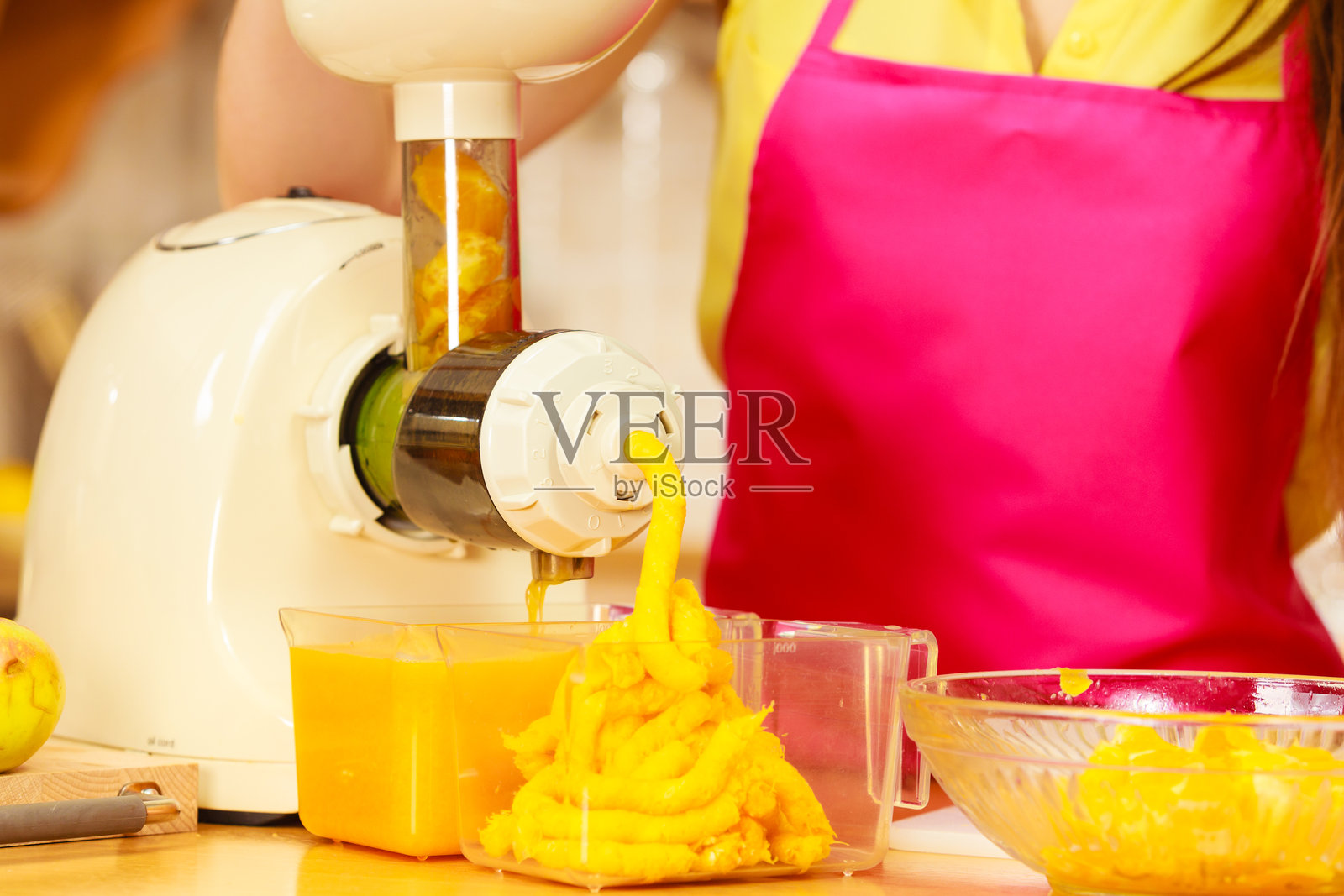 女人在榨汁机中制作橙汁照片摄影图片