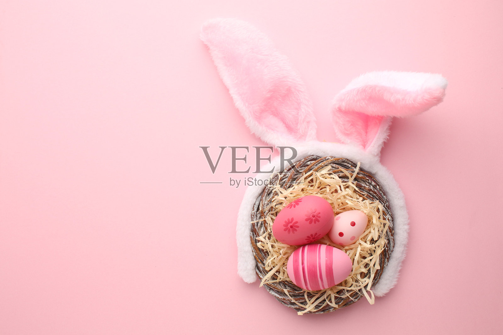 米色背景上的兔耳朵、复活节彩蛋、理发配件和雏菊照片摄影图片