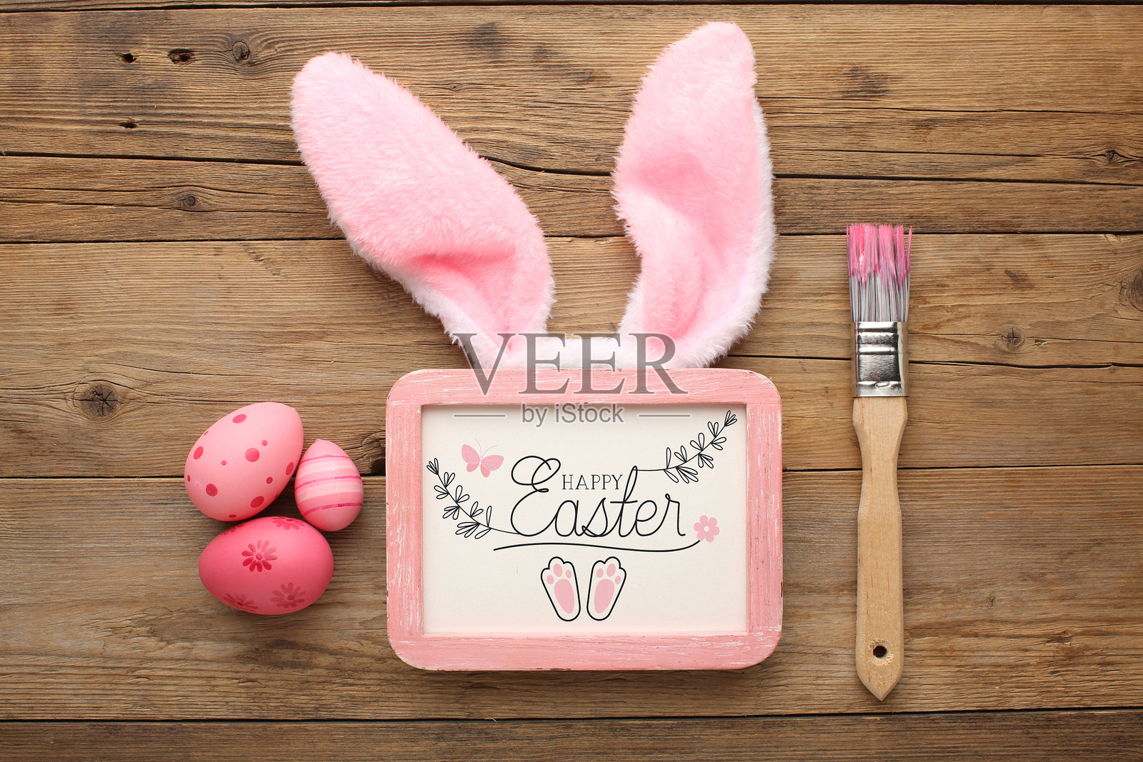 米色背景上的兔耳朵、复活节彩蛋、美发配件和雏菊照片摄影图片