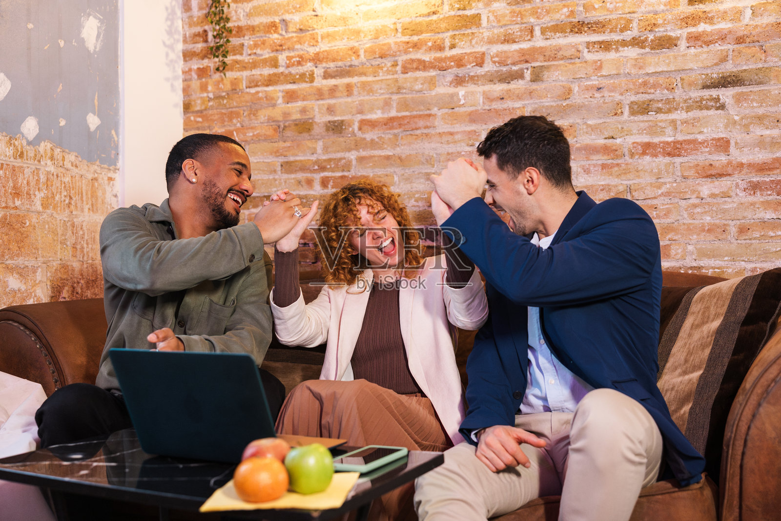 兴奋的商业团队在共享办公空间庆祝成功照片摄影图片