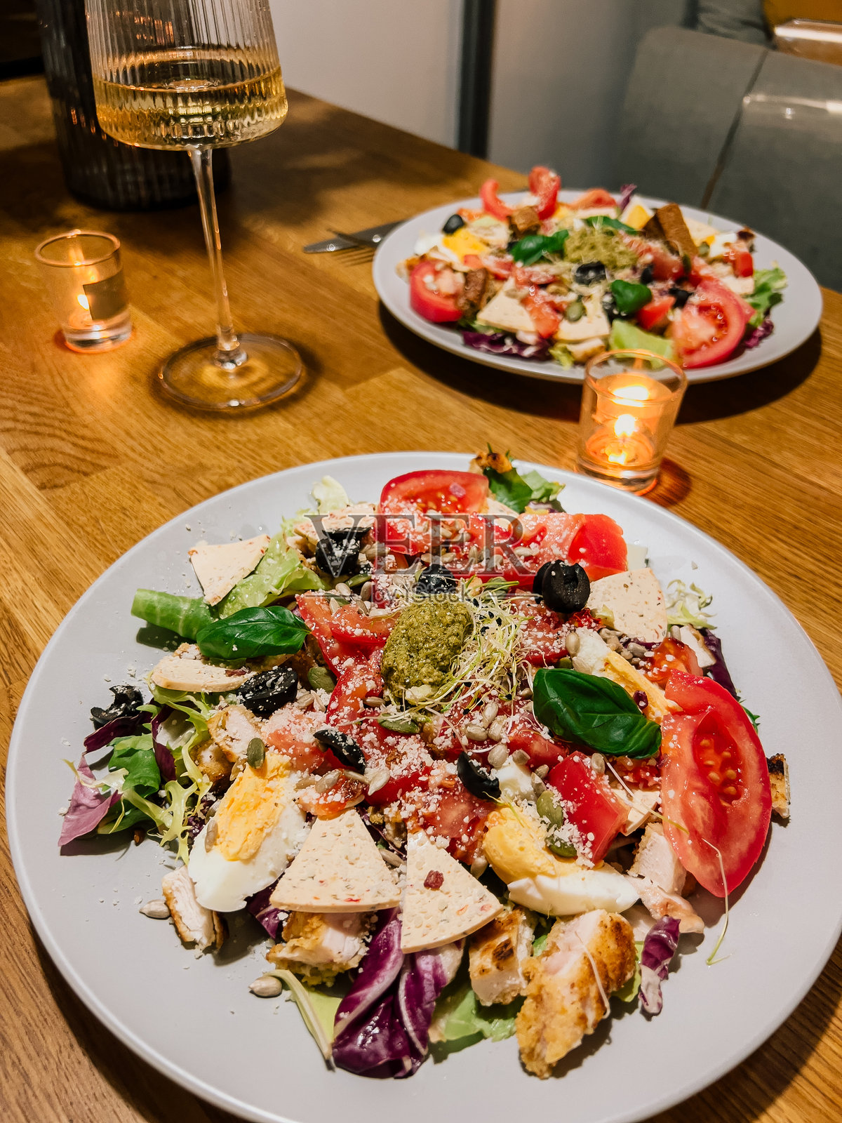 新鲜蔬菜配鸡蛋和香蒜酱,蔬菜与奶酪和香草结合,艺术地摆盘。绿叶蔬菜配番茄、鸡蛋和面包丁,绿叶和配料共同打造健康餐盘。照片摄影图片